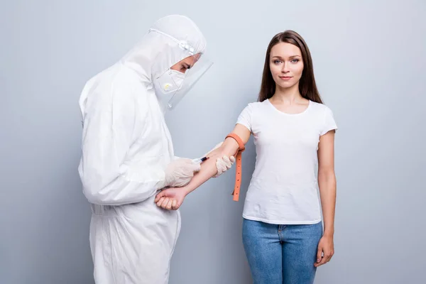 Photo of young patient lady guy doc inject take blood vein covid antibodies research vaccine hand elastic rubber wear hood uniform plastic facial protection isolated grey color background — Stock Photo, Image