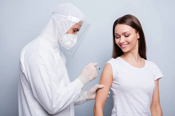 Photo of cheerful patient lady guy expert virology inject shoulder covid antidote experimental vaccine wear mask hood uniform plastic facial protection isolated grey color background — Stock Photo, Image