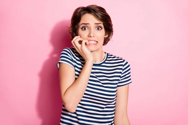 Foto de atraente assustado senhora curto penteado olhos cheios de medo mordendo dedos falha assistir filme de terror aterrorizado desgaste casual branco azul t-shirt isolado pastel cor-de-rosa fundo — Fotografia de Stock