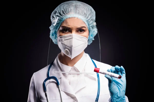 Zbliżenie zdjęcie wirologii Doc klinika trzymać sonda krwi chory pacjent pozytywny wynik nosić płaszcz maska twarzy plastik ochrona tarcza chirurgiczne czapka odizolowany czarny tło — Zdjęcie stockowe
