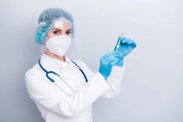 Foto de la bella dama doc examen hospitalario preparar jeringa dosis paciente vacuna tratamiento de inyección usar máscara capa facial escudo plástico tapa quirúrgica aislado color gris fondo — Foto de Stock