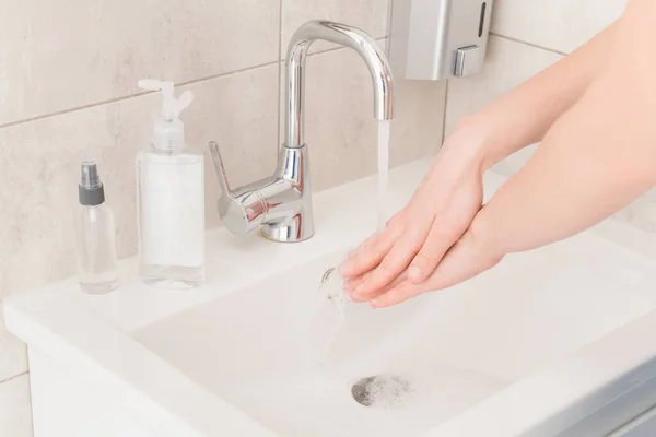 Closeup cropped photo lady wash away bubbles from arms sink hot water rub clean fingers corona virus prevention sanitation concept stop infection responsible useful habit bathroom indoors — Stock Photo, Image