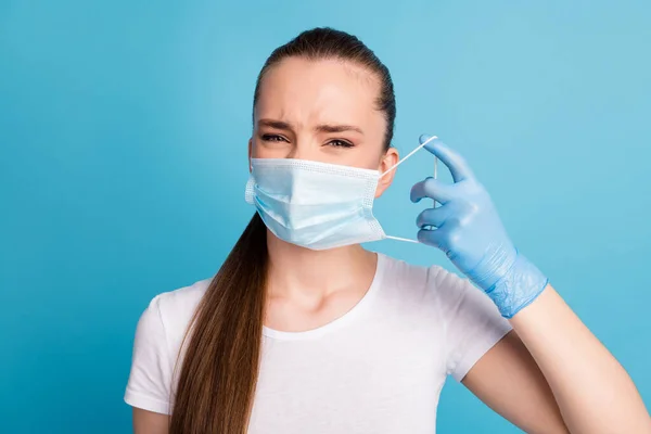 Close-up foto van mooie maar ontevreden dame slechte humeur haat altijd gebruik maken van gezichtsmaskers gevoelige huid dragen latex handschoenen beschermen gezicht masker wit t-shirt geïsoleerde blauwe kleur achtergrond — Stockfoto