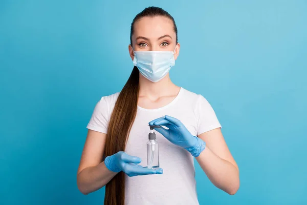 Foto de senhora muito alegre segurar as mãos anti-séptico grande garrafa desinfecção conceito de segurança aconselhando estéril cem proteção usar luvas máscara facial isolado azul cor fundo — Fotografia de Stock