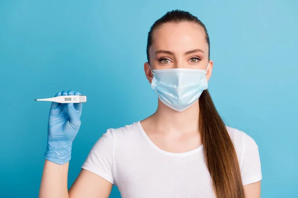 Closeup foto da bela senhora exame do hospital médico segurar termômetro mão mostrar temperatura corporal paciente desgaste proteger rosto máscara médica branco t-shirt isolado azul cor fundo — Fotografia de Stock