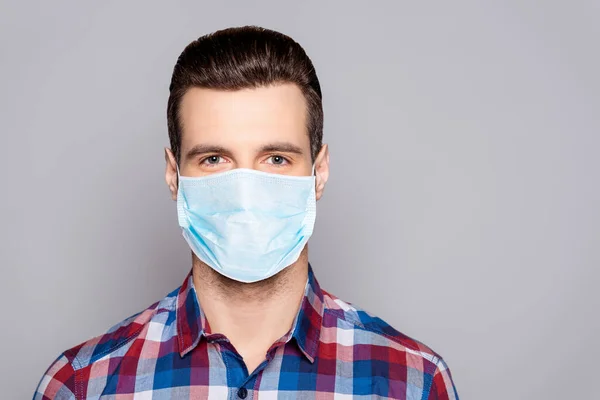 Retrato de cerca de su agradable atractivo chico de pelo castaño contenido con camisa a cuadros máscara protectora descontaminación prevención de la gripe aislado sobre fondo de color pastel gris — Foto de Stock