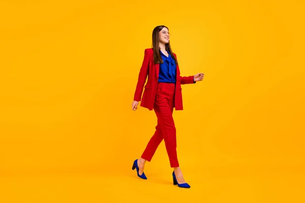 Полное фото профиля тела привлекательной уверенной в себе деловой леди босс ходить офисный центр носить спецификации красный роскошный офис пиджак брюки костюм на высоких каблуках изолированный желтый цвет фона — стоковое фото
