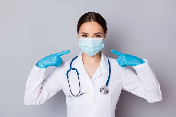 Foto do virologista doc senhora experiente profissional direto dedos seu rosto aconselhando máscara de algodão facial de boa qualidade desgaste médico uniforme jaleco estetoscópio isolado fundo cinza — Fotografia de Stock