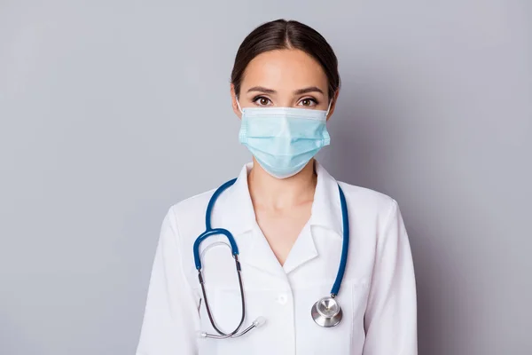 Foto de atractiva virologista doctora experimentada profesional experto escuchar paciente usar mascarilla de algodón facial uniforme médico bata de laboratorio estetoscopio aislado fondo gris — Foto de Stock