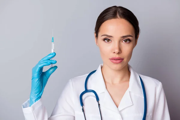 Κοντινό πλάνο φωτογραφία του επαγγελματία γιατρού σοβαρή νοσοκόμα κρατήστε τη σύριγγα προετοιμασία των ασθενών εμβολιασμός αντιβιοτικό φορούν γάντια λατέξ ιατρική ομοιόμορφη εργαστηριακή ποδιά στηθοσκόπιο απομονωμένο γκρι φόντο — Φωτογραφία Αρχείου