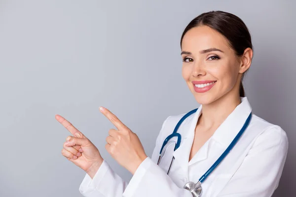 Çekici aile doktorunun yakından çekilmiş fotoğrafı profesyonel olarak boş parmaklar deneyimledi. Aşılama zamanı, hastalara tıbbi üniforma önlüğü giymelerini hatırlattı. Steteskop izole edilmiş gri arka plan. — Stok fotoğraf