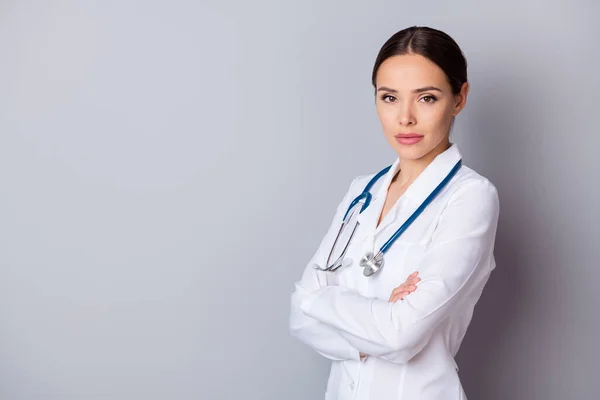 Foto de perfil de atractiva virologista médico de la familia no sonriendo experimentados brazos profesionales experimentados cruzados escuchar paciente usar bata médica bata de laboratorio estetoscopio aislado fondo gris — Foto de Stock