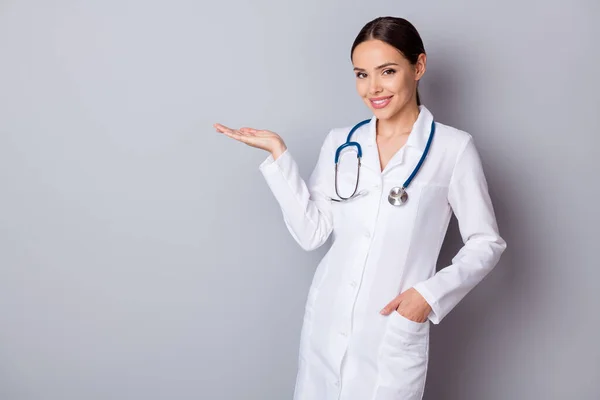 Photo of attractive family doctor doc experienced professional hold open palm arm empty space advising good quality vitamins wear medical uniform lab coat stethoscope isolated grey background — Stock Photo, Image