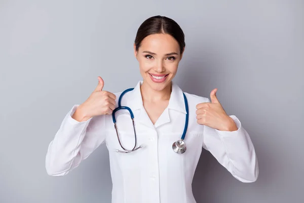 Foto von attraktiven fröhlich Familie doc erfahrene professionelle erzählen Patienten gute Nachrichten covid Test negatives Ergebnis Daumen hoch tragen medizinische Uniform Mantel Stethoskop isoliert grauen Hintergrund — Stockfoto