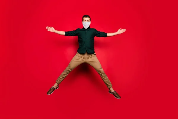 Full längd kroppsstorlek bild av trevlig attraktiv kille bär säkerhetsmask hoppa hälsosam luft miljö stoppa pandemi koncept isolerad ljus levande glans levande röd färg bakgrund — Stockfoto