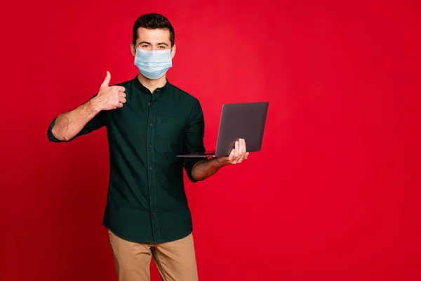 Portrait of his he nice attractive guy wearing safety mask using laptop showing thumbup stop cov ncov influenza infection prevention isolated bright vivid shine vibrant red color background — Stock Photo, Image