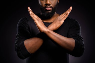 Cropped photo of serious afro american guy revolution activist cross hands x ask stop discrimination isolated over black color background clipart