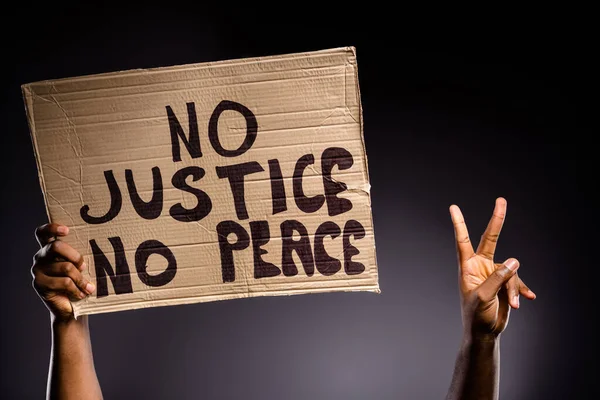Close up photo of afro american person hand hold banner no peace no justice make v-sign hope inspire symbol isolated over black color background — Stock Photo, Image
