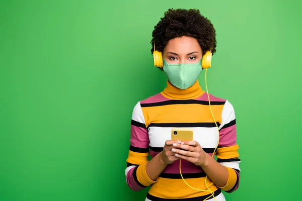 Portrait of nice attractive healthy wavy-haired girl wearing safety mask preventive gear using device browse news stop pathogen cov ncov-2 health care isolated green color background — Stock Photo, Image