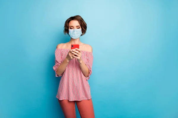 Retrato dela ela agradável atraente menina vestindo gaze máscara de segurança usando dispositivo leitura notícias sintoma síndrome gripe aperto doença isolado brilhante brilhante brilho vibrante azul cor fundo — Fotografia de Stock