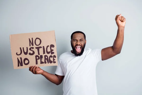 Hagyd abba a rasszizmust. Fénykép őrült sötét bőr afrikai tüntető plakát emelje ököl sikoltozó durva szlogenek közösség ellen afro polgárok törvénytelenség forradalom koncepció elszigetelt szürke színű háttér — Stock Fotó