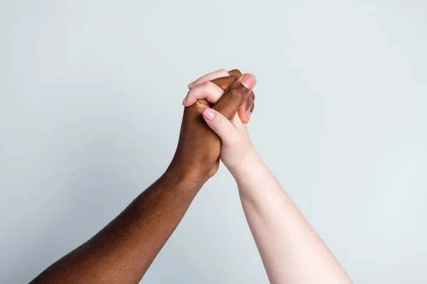 Κοντινό πλάνο φωτογραφία των δύο χεριών όπλα διαφορετική φυλή πολυεθνικό ζευγάρι καλύτεροι φίλοι θέμα κατά του ρατσισμού βοηθήσει την υποστήριξη από κοινού αγάπη σώσει κόσμο ρομαντική ημερομηνία απομονωμένο γκρι χρώμα φόντο — Φωτογραφία Αρχείου