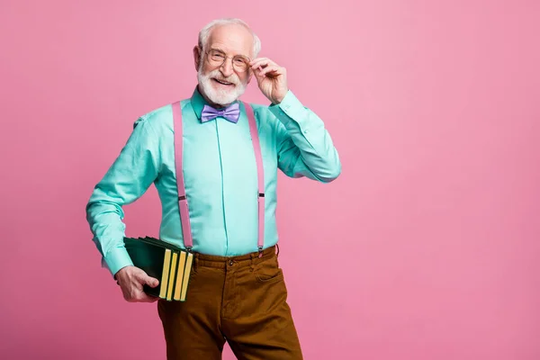 Foto av fantastiska åldrade hipster farfar hålla många böcker händer föreläsare lektioner universitet college bära specs mintskjorta hängslen fluga byxor isolerad rosa pastell färg bakgrund — Stockfoto