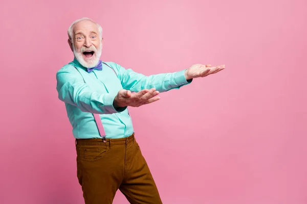 Foto de funky louco espantado vovô segurar as mãos levantado pegar atirar ar caindo novidade baixo preço produto desgaste especificações hortelã camisa suspensórios arco gravata calças isolado rosa pastel cor fundo — Fotografia de Stock