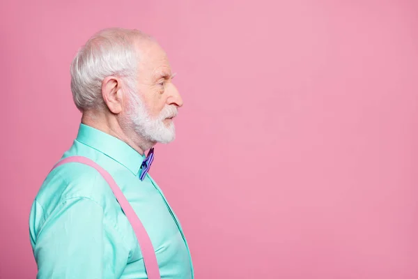 Perfil foto do vovô atraente olhando espaço vazio concentrado focado não sorrindo sério homem de negócios usar mint camisa suspensórios arco gravata isolado pastel cor rosa fundo — Fotografia de Stock