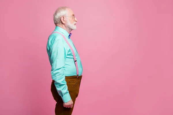 Perfil foto do vovô atraente olhando espaço vazio concentrado focado não sorrindo desgaste especificações mint camisa suspensórios arco gravata calças isoladas cor pastel rosa fundo — Fotografia de Stock