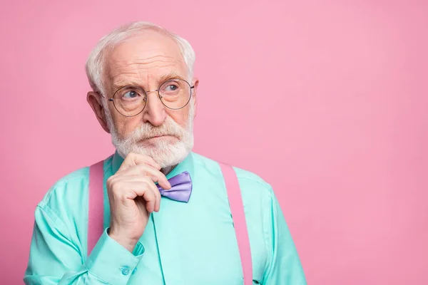 Κοντινή φωτογραφία του ελκυστικού κομψό παππού κρατώντας το χέρι στο πηγούνι αναζητήστε κενό χώρο minded φορούν specs πουκάμισο μέντας τιράντες βιολετί παπιγιόν απομονωμένο ροζ παστέλ χρώμα φόντο — Φωτογραφία Αρχείου
