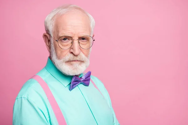 Φωτογραφία από εκπληκτικό κομψό βλέμμα παππούς σοβαρά έκφραση του προσώπου φαίνονται ευφυή ειλικρινή μάτια φορούν specs mint πουκάμισο τιράντες βιολετί παπιγιόν απομονωμένο ροζ παστέλ χρώμα φόντο — Φωτογραφία Αρχείου