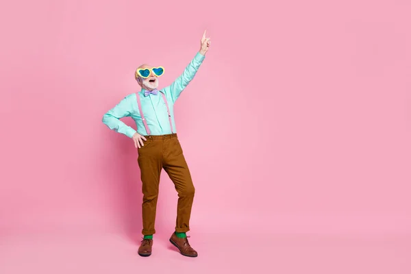 In voller Länge Foto von verrückten Opa Senior Meeting Freude direkt Finger nach oben leeren Raum tragen Spezifikationen Hosenträger Hemd violette Fliege Hose Schuhe Socken isoliert pastellrosa Farbe Hintergrund — Stockfoto