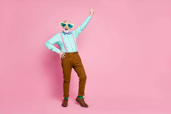 Yaşlı komik büyükbabanın tam vücut fotoğrafı dans eden yıldız sevinçten parmak kaldırıyor gözlük takıyor gömlek giyiyor menekşe papyon pantolon çoraplar izole pembe pastel arka plan — Stok fotoğraf