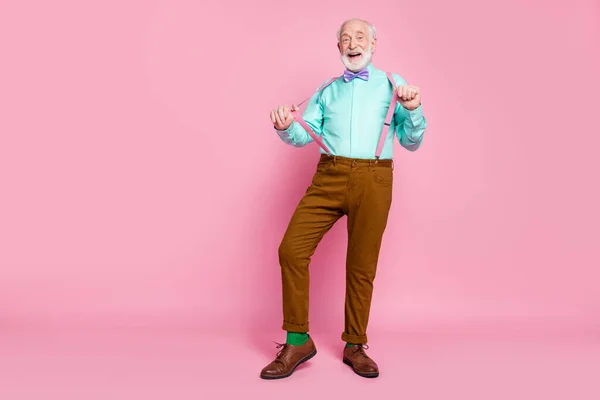 Teljes hosszúságú fotó vicces nagyapa pozitív érzelmek senior party találkozó érintse ujjak nadrágtartó viselni ing lila csokornyakkendő barna nadrág cipő zokni elszigetelt rózsaszín pasztell háttér — Stock Fotó