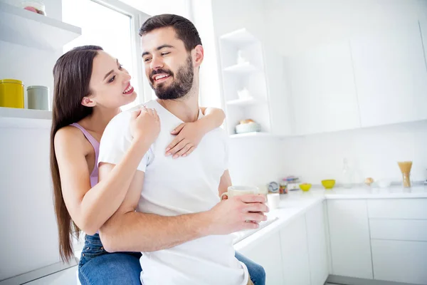 Photo de deux personnes homme femme étreinte étreinte piggyback avoir repos détente week-end homme tenir tasse boisson café latte fille asseoir fenêtre seuil dans la cuisine maison à l'intérieur — Photo
