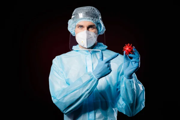 Photo of serious guy doc virolog direct finger covid bacteria vaccine research pcr analysis wear mask hazmat blue uniform surgical cap face shield isolated black color background — Zdjęcie stockowe