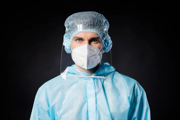 Primo piano foto di bel ragazzo esperto doc virologia centro covid19 protezione indossare maschera respiratoria hazmat blu uniforme tuta plastica facciale scudo isolato colore nero sfondo — Foto Stock