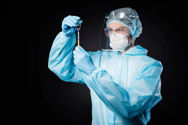 Photo of guy expert doc virolog prepare antidotum bottle injection visit sick covid patient wear mask hazmat uniform suit plastic face protection shield isolated black color background — Zdjęcie stockowe