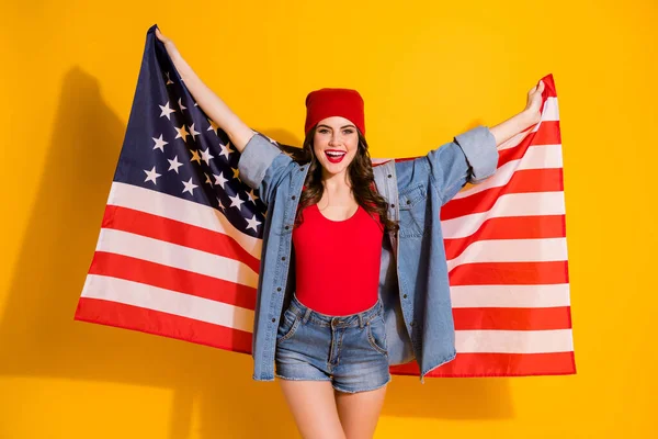 Πορτρέτο της τάσης της νεολαίας έφηβος κορίτσι διεθνής φοιτητής κρατήσει ΗΠΑ σημαία απολαύσετε τέταρτο Ιούλιο διακοπές φορούν κόκκινο καπέλο denim singlet φορούν απομονώνονται σε φωτεινό φόντο χρώμα — Φωτογραφία Αρχείου