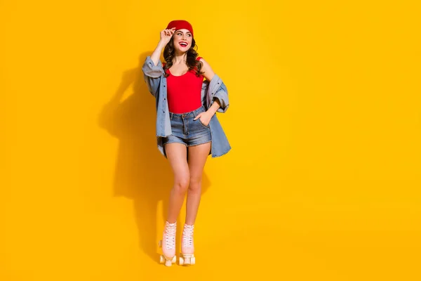 Foto em tamanho completo alegre funky jovem menina adolescente desfrutar de patins de rolo descanso de fim de semana desportivo olhar bom copyspace toque mãos headwear desgaste singlet jeans isolado brilhante cor viva fundo — Fotografia de Stock