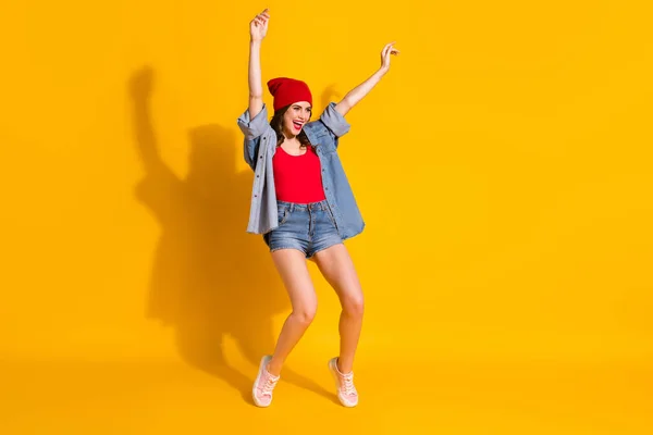 Volledige lengte foto positief jong hipster meisje dans lente weekend discotheek nachtclub verhogen handen dragen rood hoofddeksel goed kijken kleding sneakers geïsoleerde heldere kleur achtergrond — Stockfoto