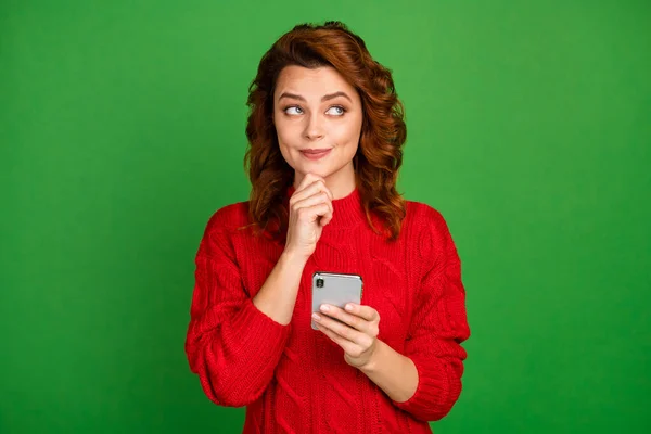 Portret van geïnspireerde geïnteresseerde vrouw gebruik smartphone denken gedachten raken kin vinger beslissen wat voor soort slijtage jumper geïsoleerd over heldere kleur achtergrond — Stockfoto