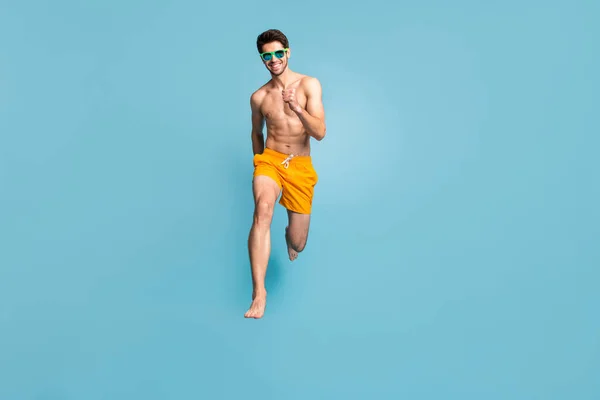 In voller Länge Körpergröße Ansicht seiner er schön attraktiv fröhlich zielstrebig Kerl in Badehosen springen Spaß beim Laufen isoliert auf hellem lebendigen Glanz lebendigen grün blau türkis Hintergrund — Stockfoto