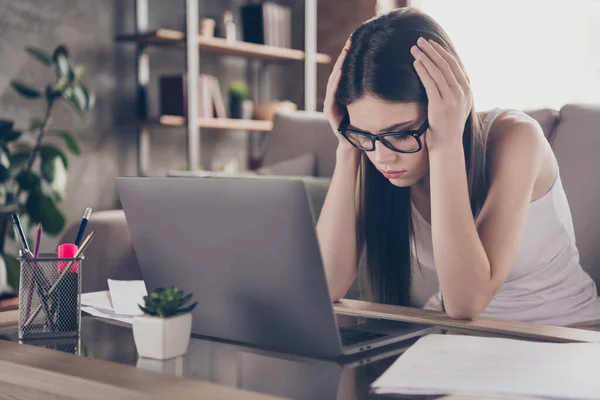 Porträtt av frustrerad utmattad flicka manager beröring händer huvud känsla migrän arbete avlägsen bärbar dator missa deadline start presentation sitta divan i huset inomhus — Stockfoto