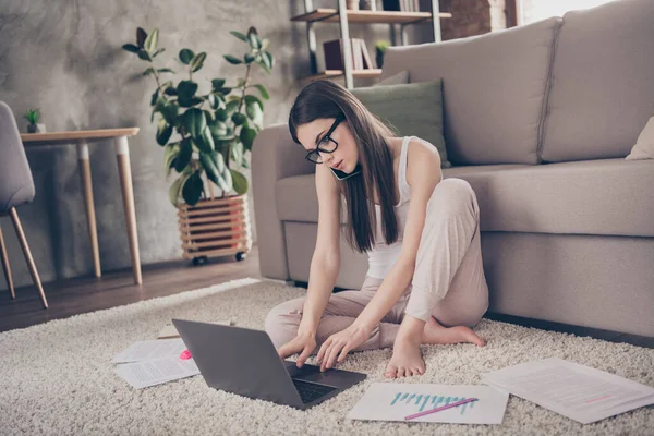 Full body photo of focused girl manager marketer work distance laptop typing chatting have problem call smartphone speak tell talk say colleagues executive sit carpet in house indoors — Stock fotografie