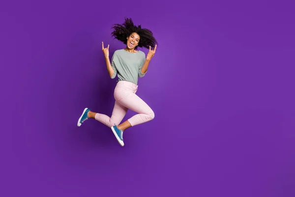Foto de comprimento total de louco funky afro americano menina rocker jump show horne sign desfrutar de pank show vestir camisa listrada roupas rosa isolado sobre cor roxa fundo — Fotografia de Stock