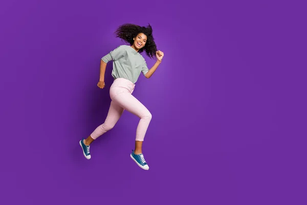 Foto de corpo inteiro de alegre afro americano menina salto correr rápido depois de preto sexta-feira descontos desgaste casual estilo roupa calças isoladas sobre cor violeta fundo — Fotografia de Stock