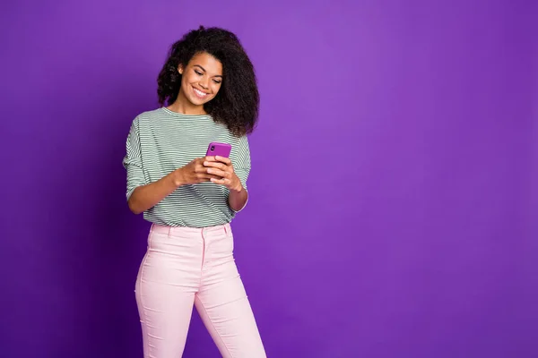 Retrato de interessado bonito doce afro-americano usar seu celular ler notícias de mídia social desfrutar de post no blog vestir roupa jovem moderna isolado sobre fundo cor violeta — Fotografia de Stock