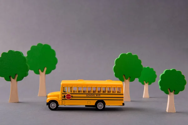 Imagem de design de arte de ônibus escolar levando as crianças de casa para a escola primária entre a fortaleza isolada sobre fundo de cor pastel cinza — Fotografia de Stock